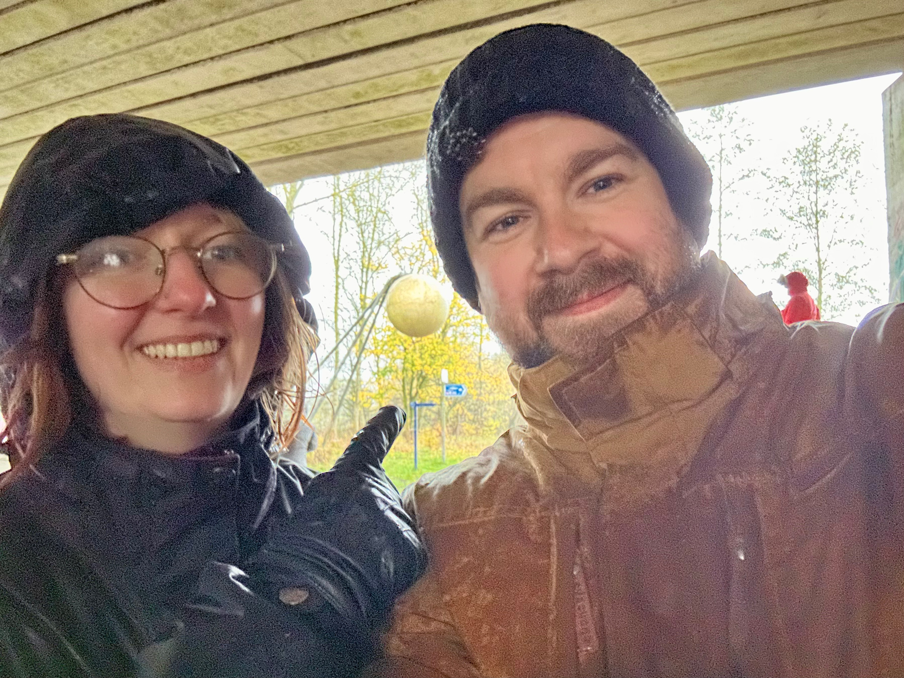 Charlotte and I sheltering under a bridge. We're wet from the rain and we're pointing at a large model of the sun at the end of the solar system walk