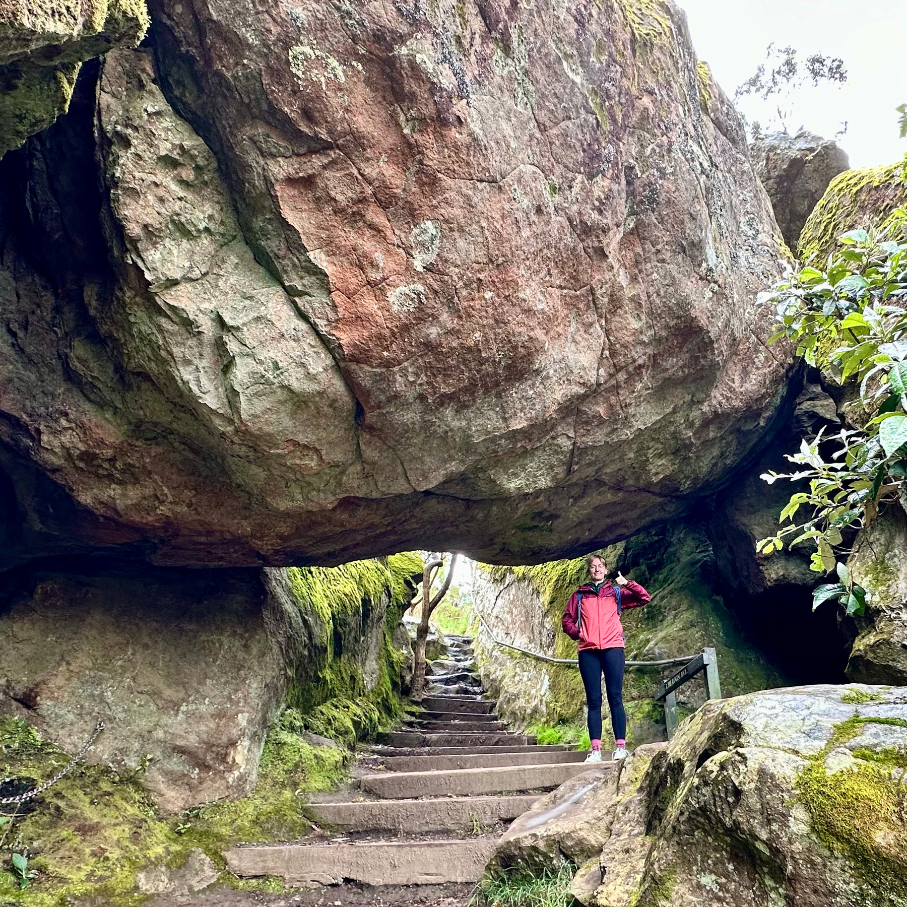 Charlotte standing beneath a large suspended rock