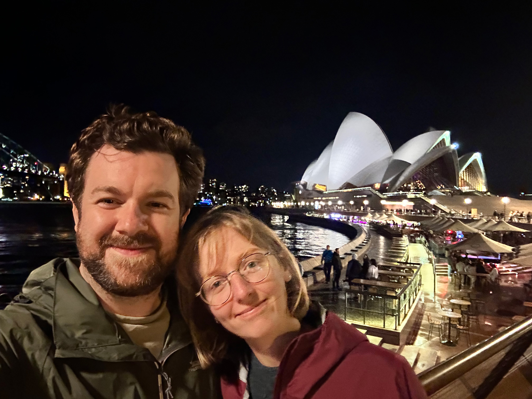A selfie of me and Charlotte standing in front of Sydney Opera House on a rainy night