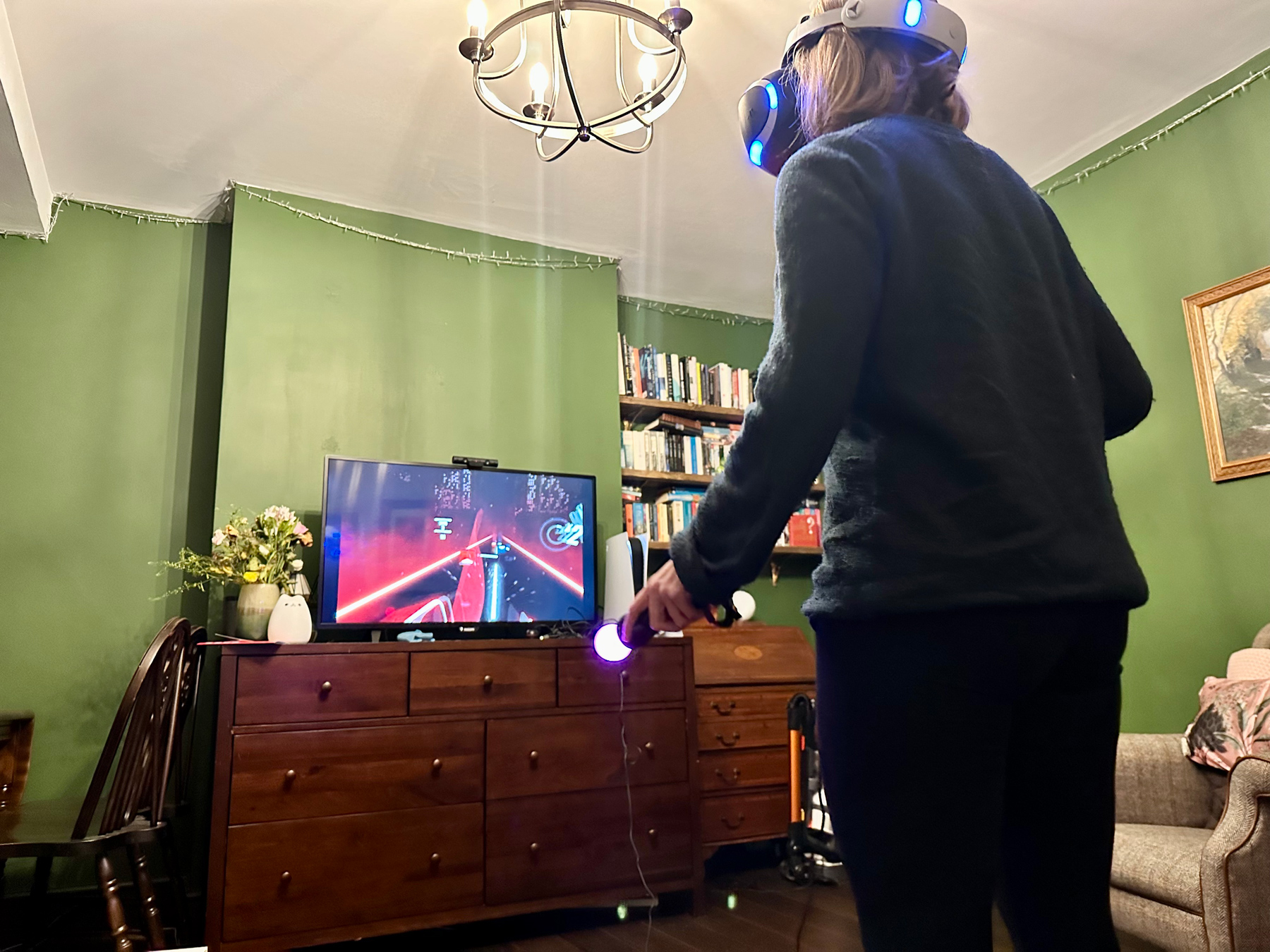 Charlotte stood in our living room playing Beat Saber