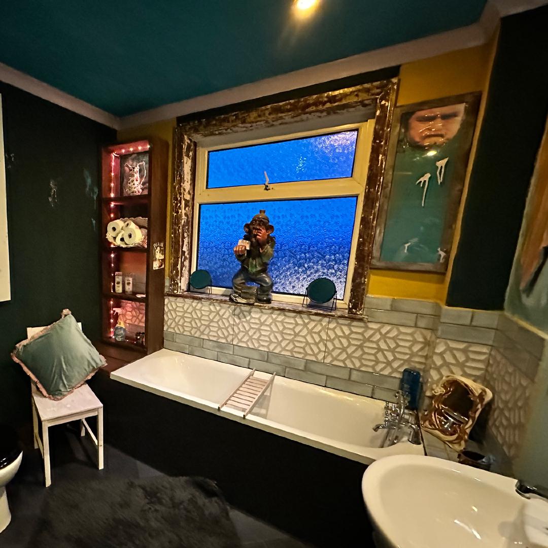 A bathroom full of odd ornaments and paintings