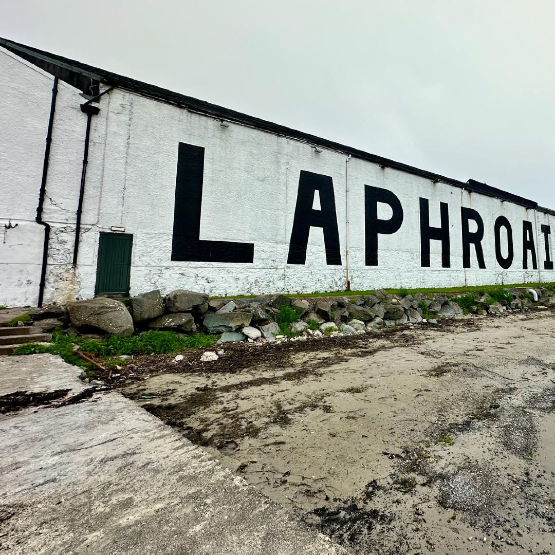 The Laphroig sign, painted black on white brick, viewed from the beach