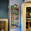 A wooden spice rack full of jars and expertly hung on the wall
