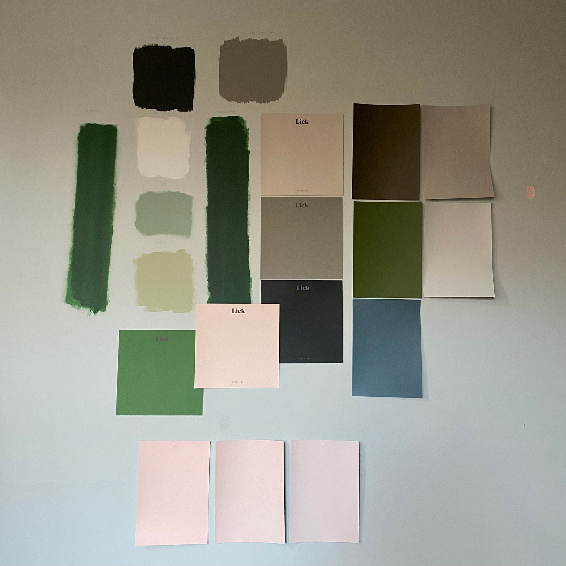 A wall covered in 20 different green and neutral paint patches