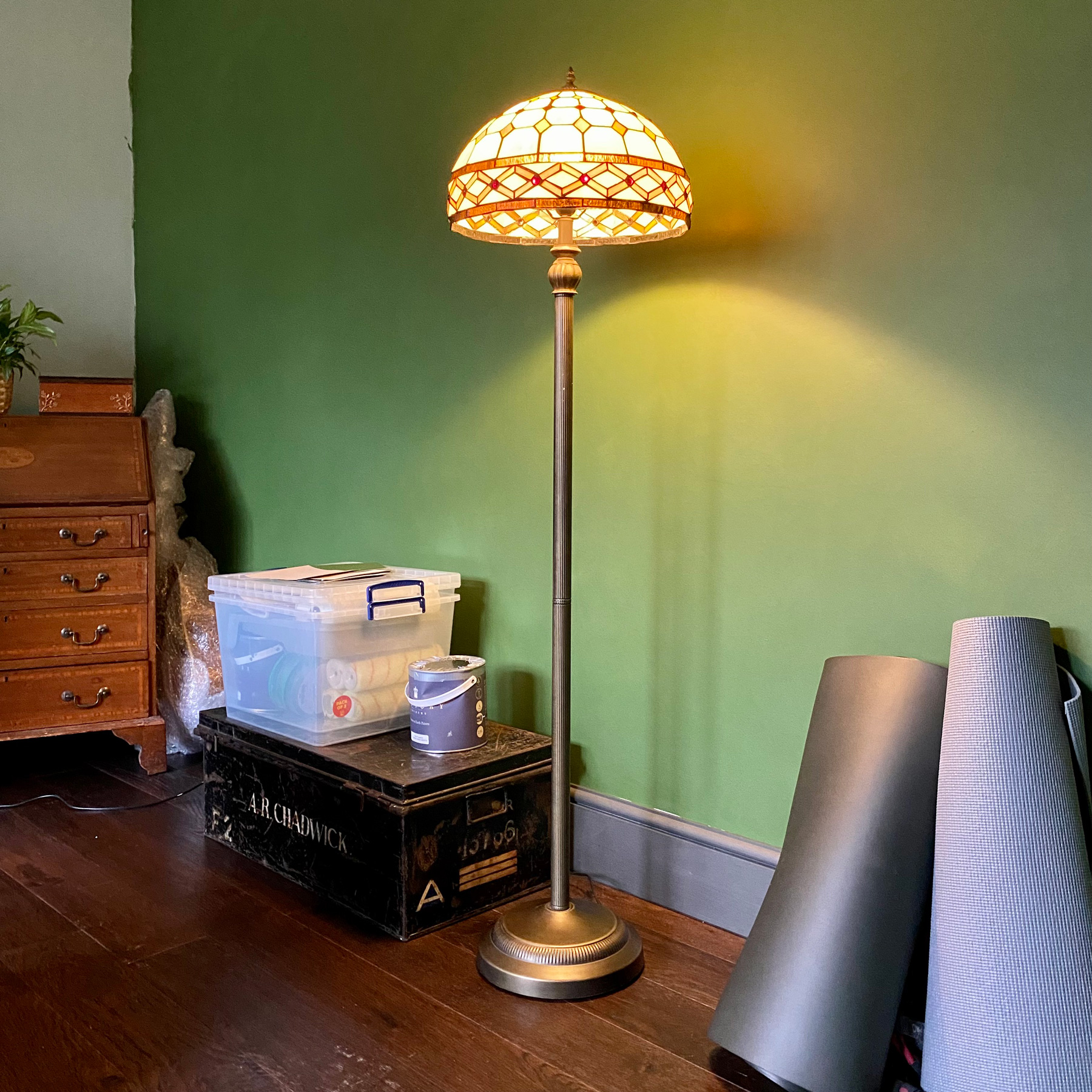 A Tiffany style floor lamp with a brass stand.