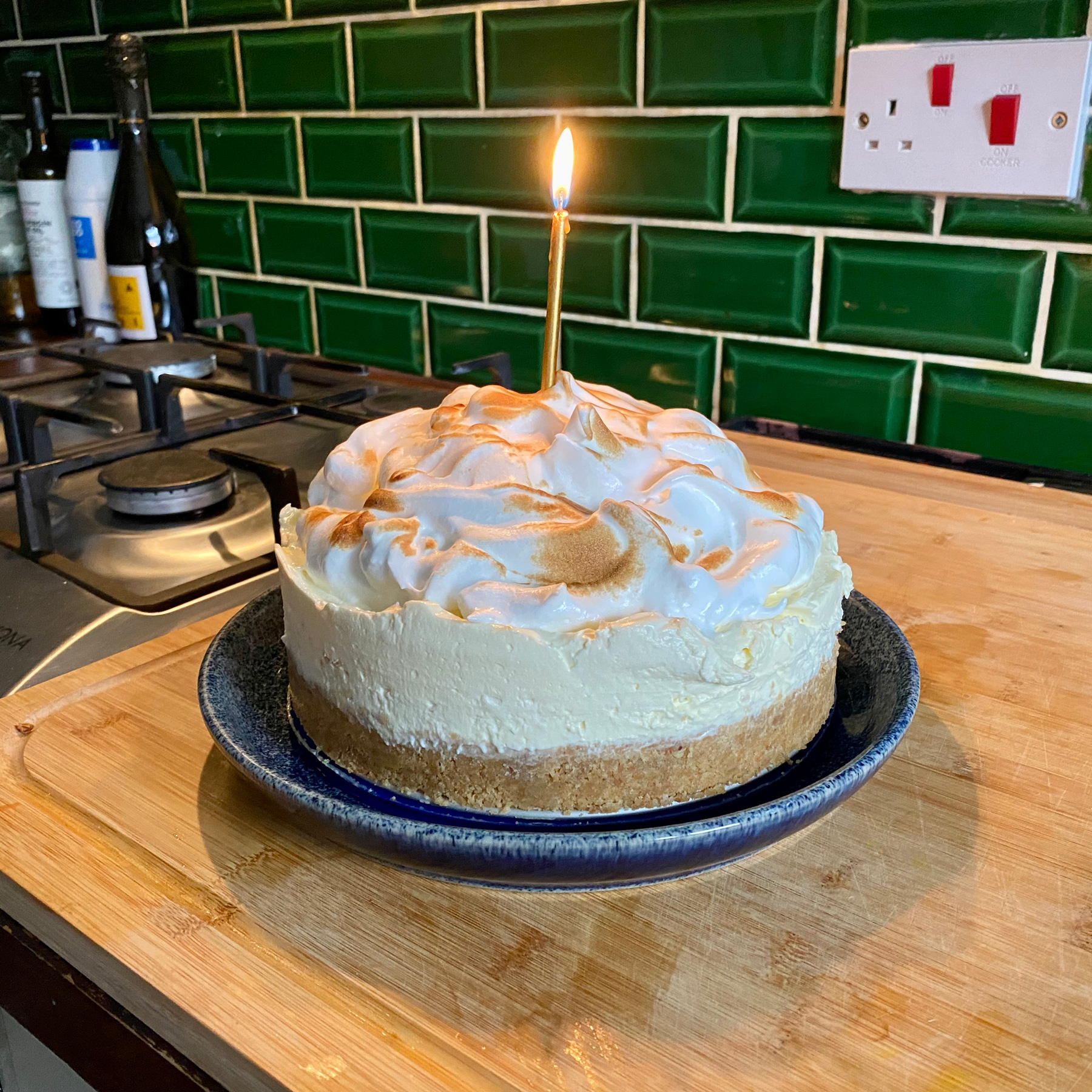 A beautiful-looking cheesecake topped with Italian Meringue and a single candle