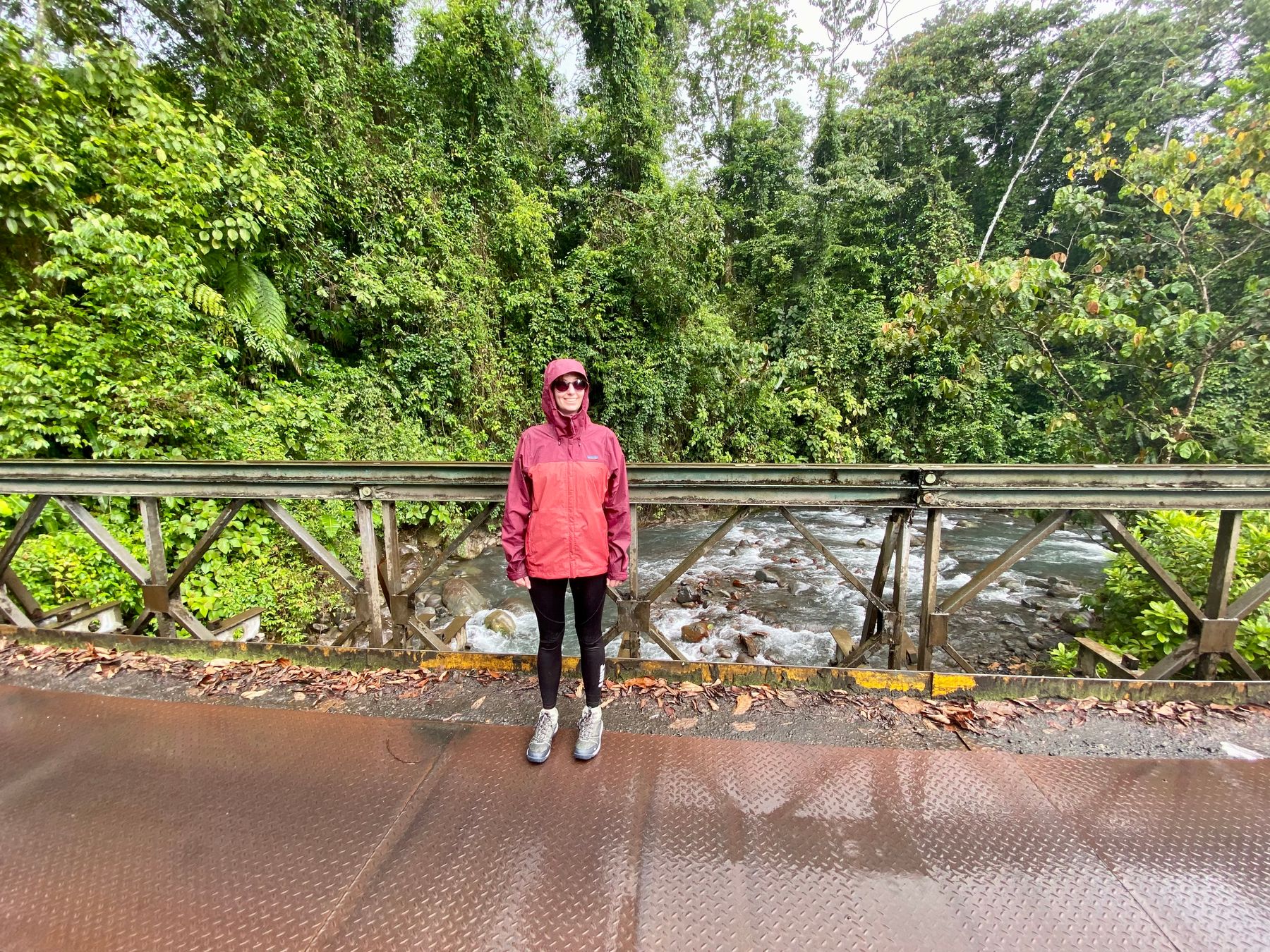 Charlotte standing on a bridge in the rain