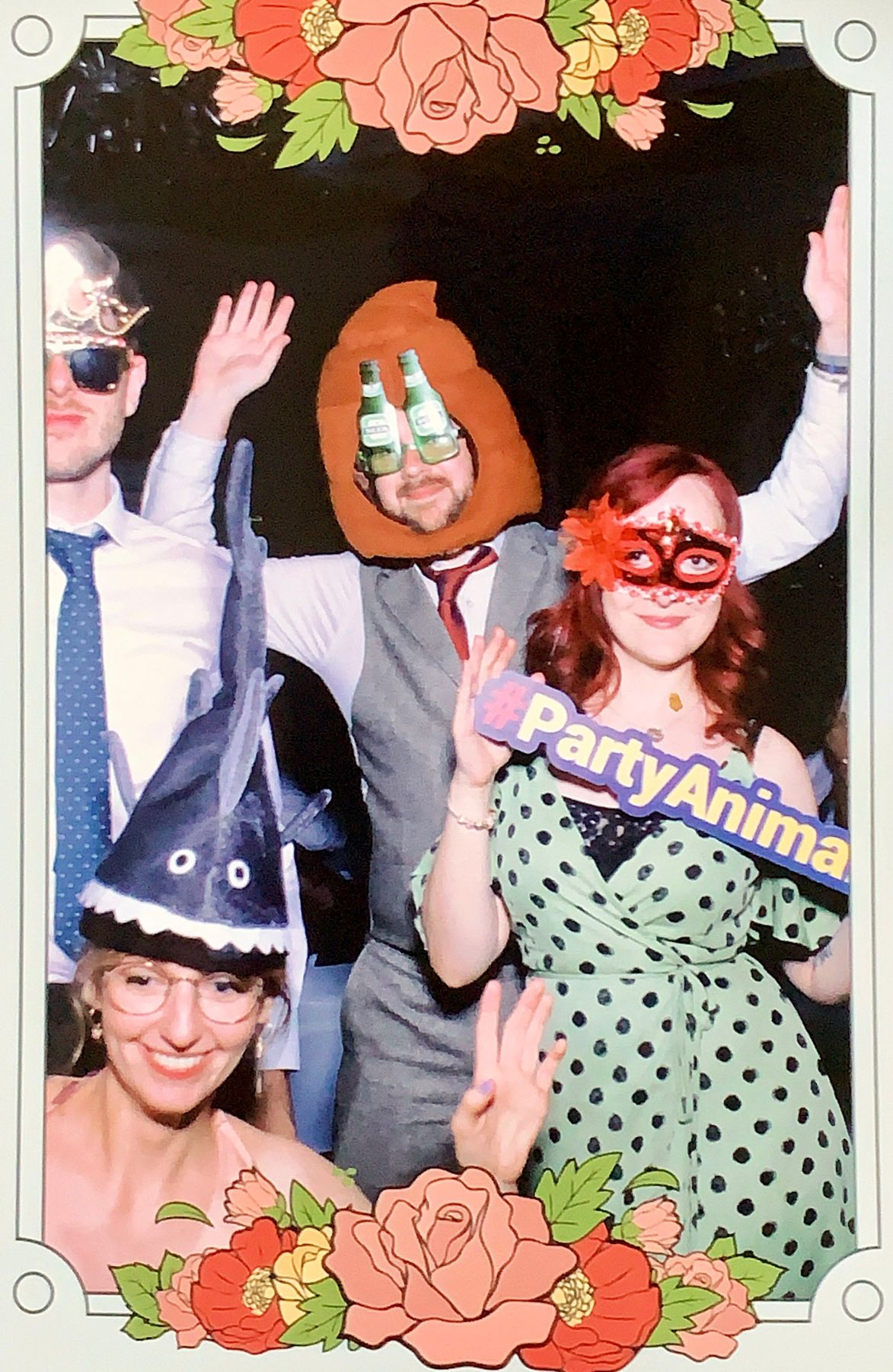 Me, Charlotte, Jenn, and Chris in a photo booth. I'm wearing a poop-shaped hat and beer glasses, Chris is wearing a tiara, Jenn is wearing a mask, and Charlotte has a shark hat on